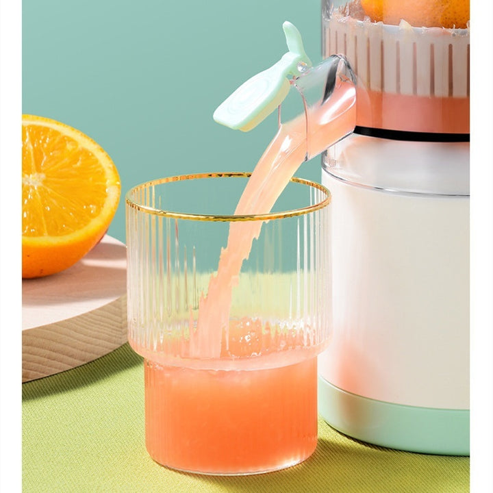 Orange juice being poured from a manual juicer into a glass with a light blue background.