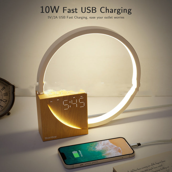 Wooden digital clock with LED ring and smartphone for fast USB charging on a white surface.
